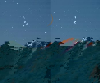 The moon at night over mountains