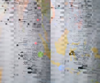 Map of the world with pins stuck in different places.