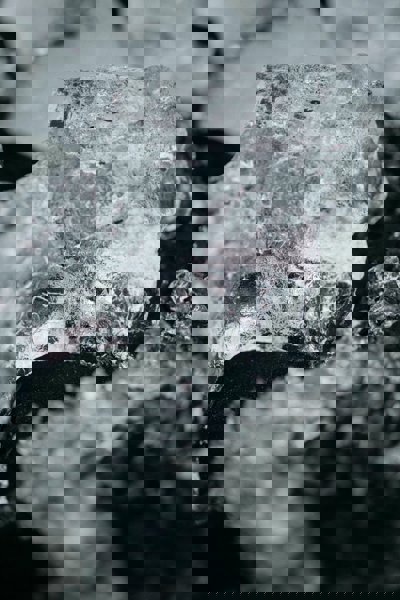 Close up photography of a stone - Ice on a black pebble