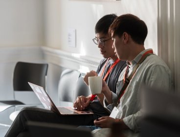 Two academics at an RGS conference looking at a laptop.