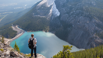 Person with backpack overlook mountain lake
