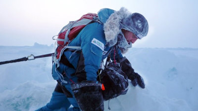 Martin Hartley in full winter gear in an Arctic environment against a backdrop of snow and ice.