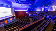 View from the balcony in the Ondaatje Theatre at the Royal Geographical Society. A presentation slide is projected on the screen and says 'Welcome to the Roayl Geographical Society'.