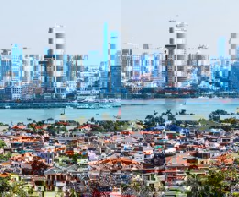 Traditional Chinese buildings and a city with new skyscrapers divided by a river.