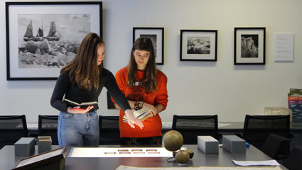 Two people beside a table looking at slides laid on a lightbox.