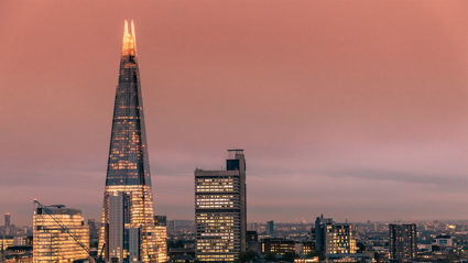 Modern London city skyline with the Shard building at sunset.