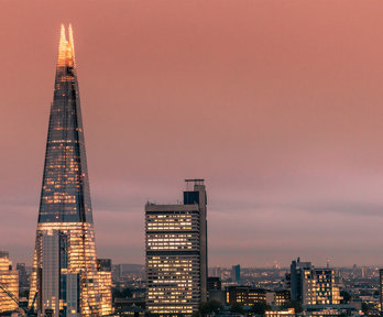 Modern London city skyline with the Shard building at sunset.