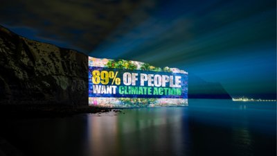 Climate change activism light show. The text reads: 89% of people want climate action.