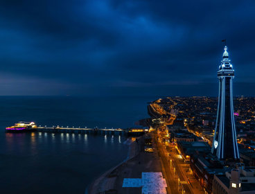 Blackpool at night, with neon lights that show the outline of the coastal area