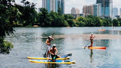 Three people stand up paddle boarding 