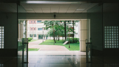 A university campus with open doors leading out to a garden.