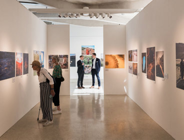 A shot inside the Earth Photo exhibition with guests viewing the photographs. 