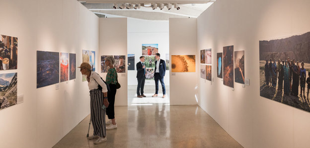 A shot inside the Earth Photo exhibition with guests viewing the photographs.