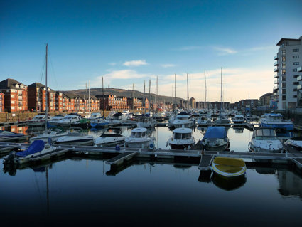 View over a harbour with white boats, red brick buildings andf blue sky