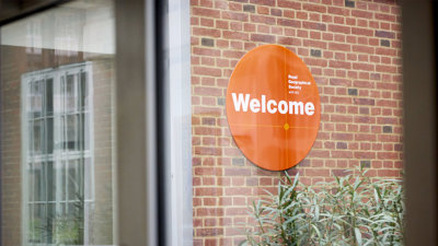 Welcome sign of the Royal Geographical Society (with IBG) seen through a window.