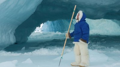 Bruce Parry in snow gear within ice structure.