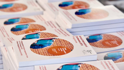 A stack of International Conference 2019 programmes with one programme booklet in focus.