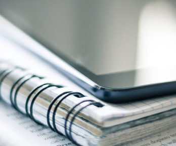 Tablet on top of a notebook.