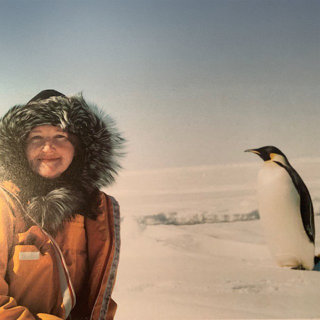 Meredith Hooper and a penguin in Antarctica.