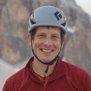 Kieran Wood wearing a grey helmet and red sweater.