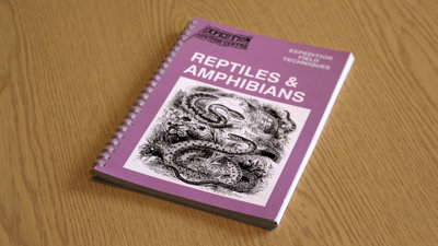 A copy of Expedition Field Techniques: Reptiles & Amphibians on a desk.