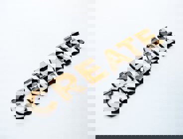 The word 'create' in wood on a white background