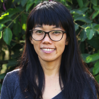 Person with black hair and fringe smiling.