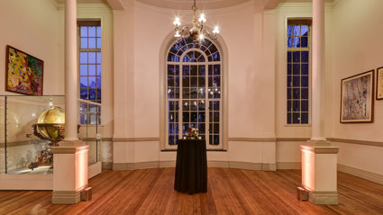 A formal reception set-up in the Map Room with warm evening lighting. 