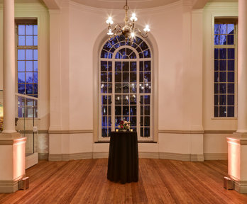 A formal reception set-up in the Map Room with warm evening lighting. 