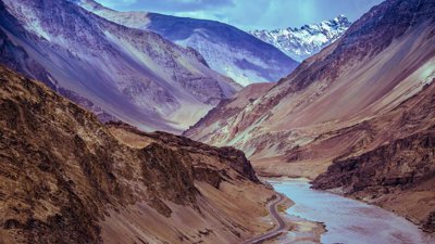 Mountain valley with a river and road running through the valley floor.
