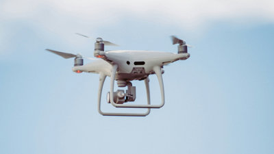 Drone flying through a blue sky.